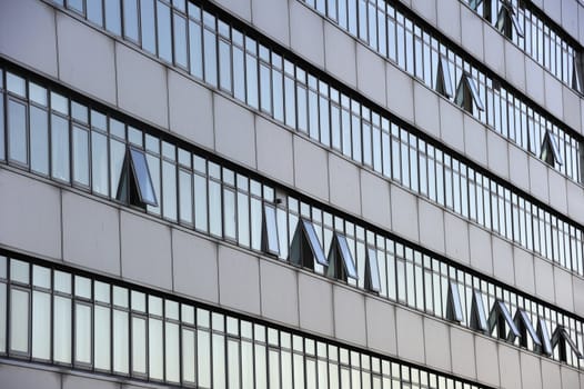 Detail of the facade of an office block with open windows