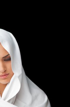 half face of a young female wearing white veil over her head isolated on black