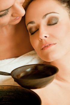 Close-up of two beautiful women enjoying aroma therapy in sauna