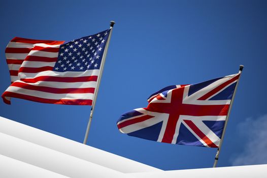 English and American flag in the wind on blue sky - U.S. and UK