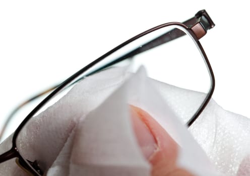 Macro image of a soft white cloth cleaning the lens of a pair of spectacles