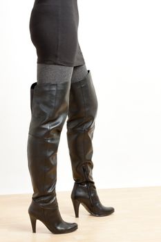 detail of standing woman wearing fashionable black boots