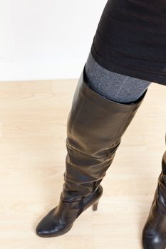 detail of standing woman wearing fashionable black boots