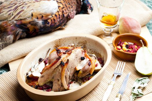 baked pheasant with bacon, pear, raisins on brandy
