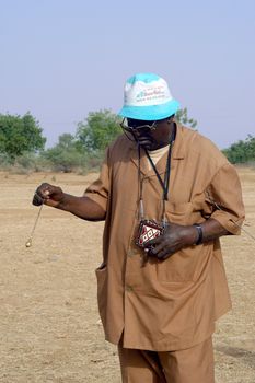 African waterfinder with work in an area of Burkina Faso Faso. Water is not rare in Africa, only it is necessary to drill wells to reach it. The waterfinder thus determines the place exact where to drill because drilling costs 8000 ? and it is not question of missing the place where the machines will have to work.