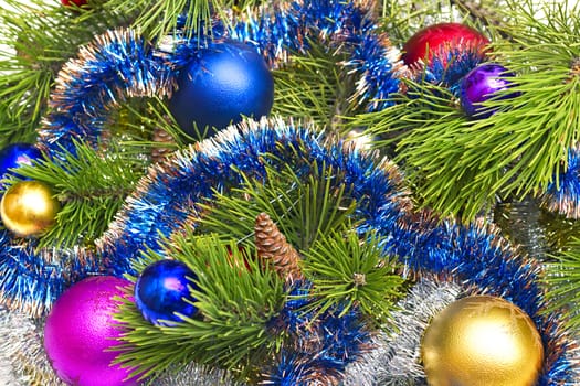 pine branch with cones and Christmas decorations in the background