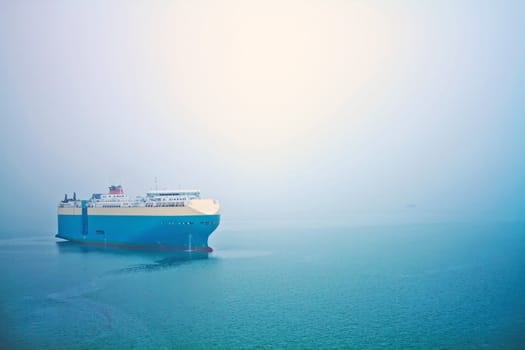 A global cruise stops in the sea in a foggy day