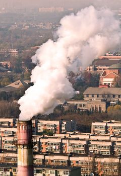 Landscape photo of chimney, smoke and air pollution in residental block