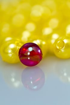 Close up of a red bead in front beads with shallow DOF, with mirror image portrait orientation