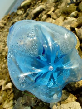 Blue PET bottle near river line