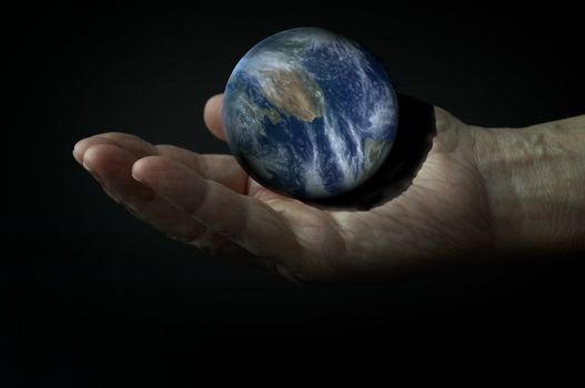 Earth on the hand in the darkness