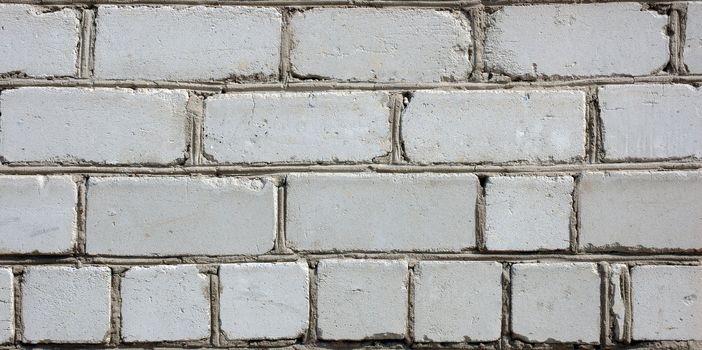 Old gray brick wall. White (in past) silicate bricks like background.