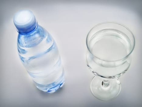 Bottle of water and glass on a white background