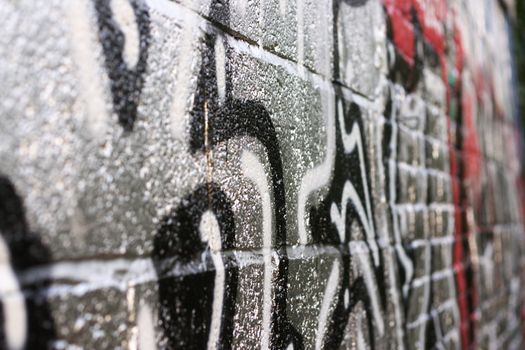 Detail of a grafitti, silver brick wall. Shallow depth of field.