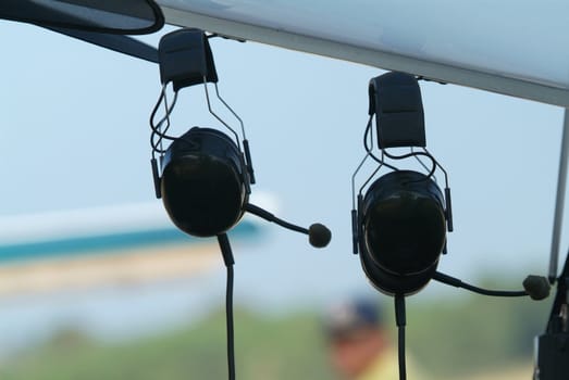 Two headsets hanging in the cockpit of a light airplane. Very shallow depth of field.