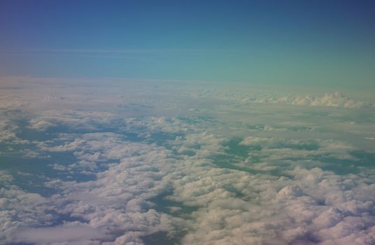 aerial view over clouds, rainbow effect due to polarizer