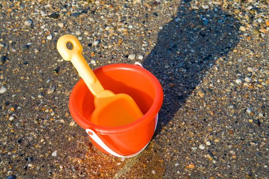 Red bucket and yellow spade on tropical beach