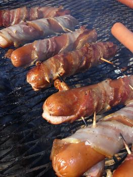 Sausage in bacon over grill