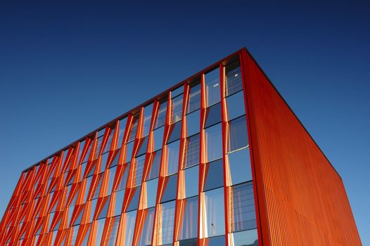 An orange office block standing out strongly against a clear blue sky