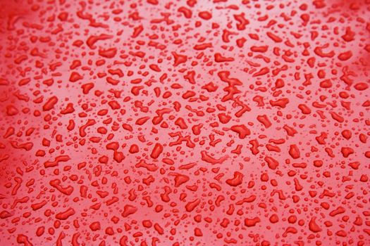 Water Droplets on a Red Steel Surface. Close-up