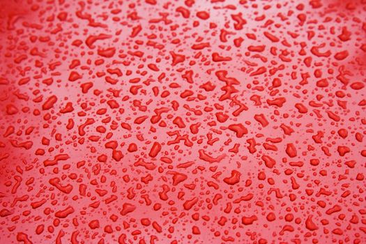 Water Droplets on a Red Steel Surface. Close-up