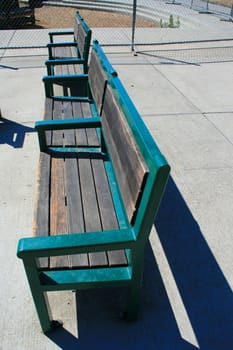 Close up of the two green benches in a park.
