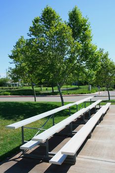 Empty bleachers on a stadium in a park.
