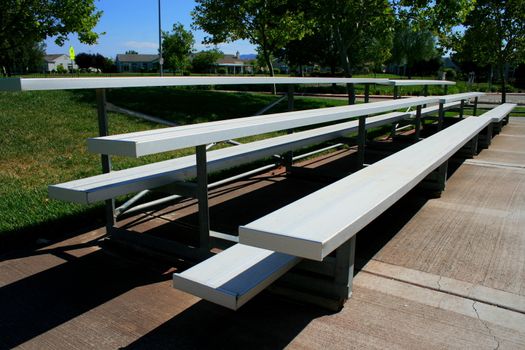 Empty bleachers on a stadium in a park.
