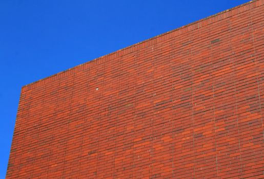 Brickwall over blue sky showing unique pattern.
