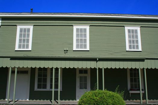 Close up of a green wooden building.
