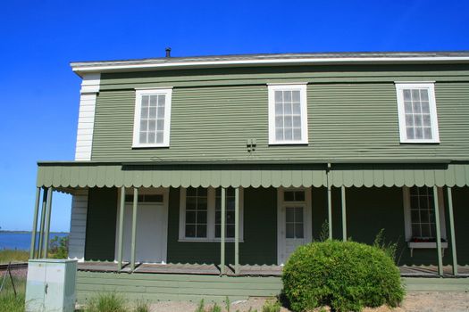 Close up of a green wooden building.
