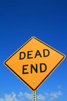 Dead end road sign over blue sky.
