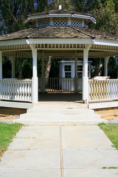 Close up of a white gazebo in a garden.
