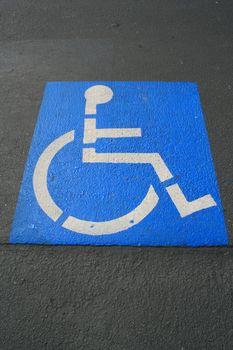 Close up of a handicap sign on a pavement.
