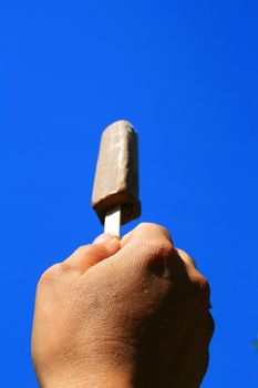 Close up of a hand holding ice cream.
