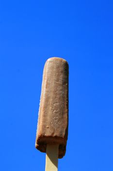 Close up of a chocolate ice cream over blue sky.
