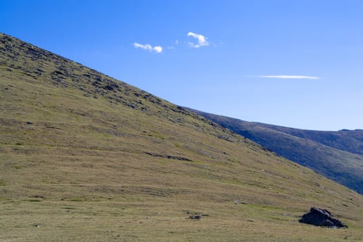 woodless stony mountainside and cloudly sky
