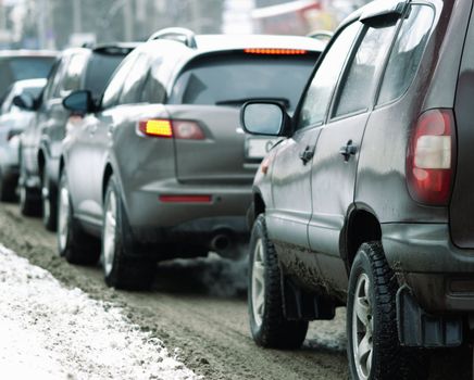 winter time,focus point on the automotive head lamp of the nearest car