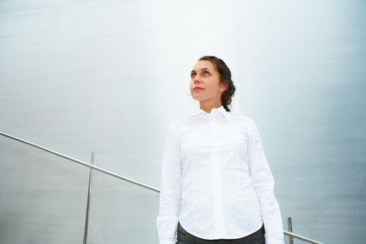 Young woman contemplating outside building