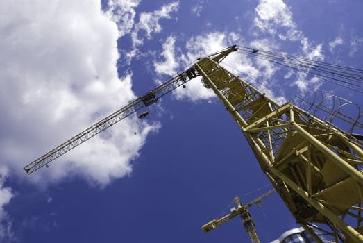 cranes and building on sky background, special photo f/x, focus point on nearest partof crane