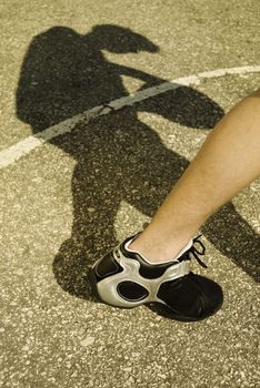 basketball shoe and shadow of the player, speciaal toned, focus point on the leg