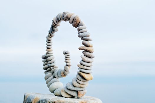 White spiral of pebbles on the boulder at the sea