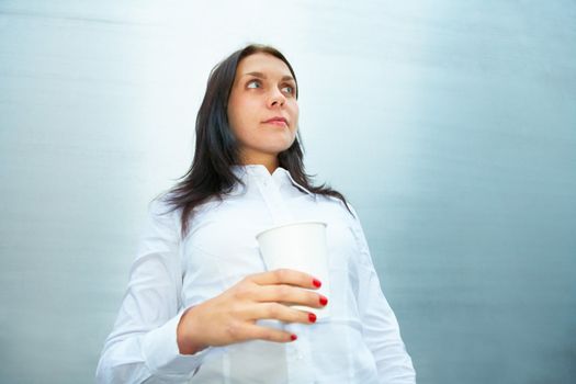 Young woman contemplating holding coffee cup
