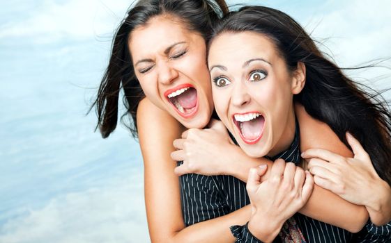 Two beautiful girls hugging and screaming with excitement