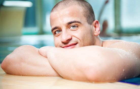 Close-up of young attractive male posing in a swimming pool