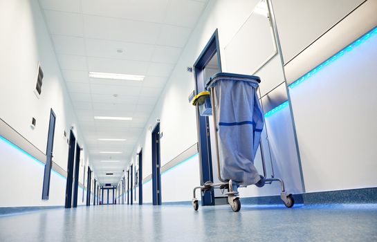 clean white long hospital corridor with blue leading lights