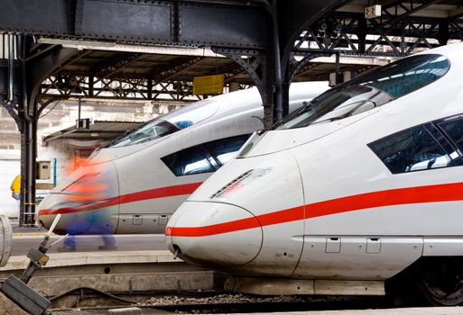 Two modern express trains waiting at platforms on station