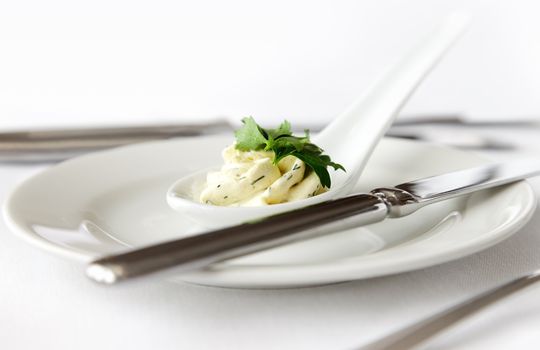 butter with parsley in a ceramic spoon on plate