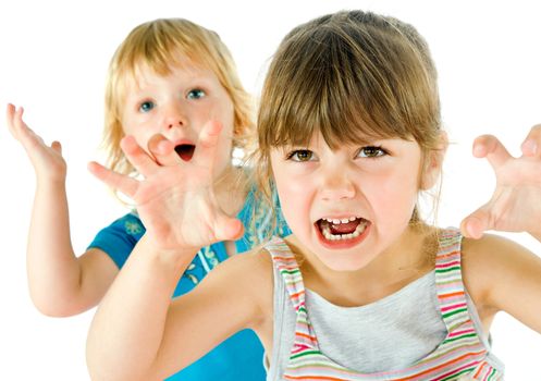 Portrait of two little kids playing, making scary grimaces isolated on white