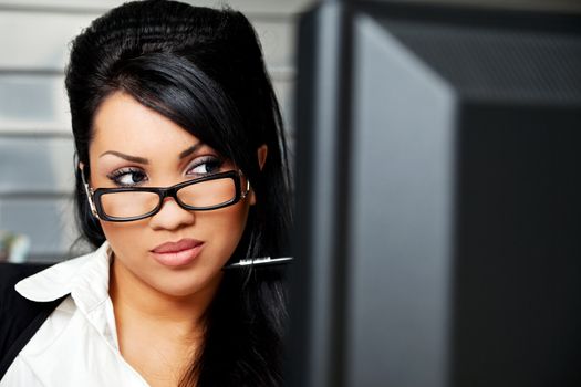 hispanic female with black hair and glasses behind monitor